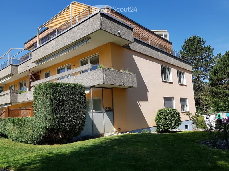 Two-story house with balconies, modern design, and well-maintained garden.