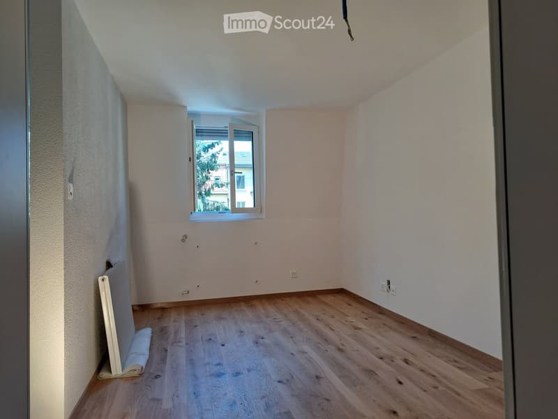 Empty room with wooden flooring, white walls, and a window with white frame. No furniture or equipment present.