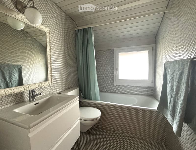 Bathtub, white sink, white toilet, silver faucet, small mirror, white wall, white towel hanging, green curtain