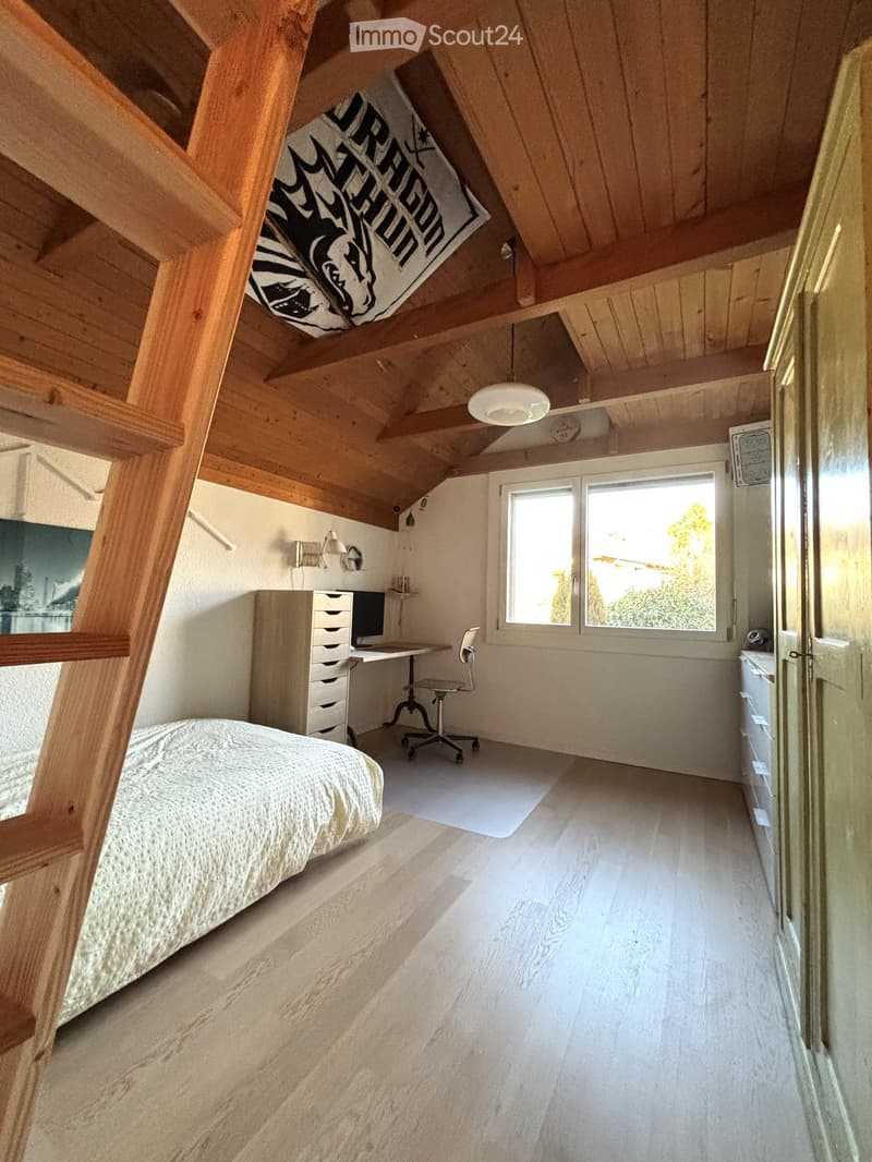 a bed, desk, chair, wooden ladder, wooden ceiling, wooden flooring