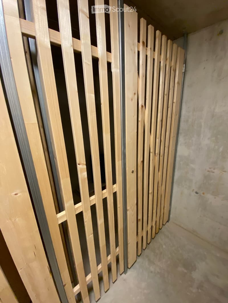 Empty room with unfinished wooden paneling and concrete walls, no furniture or equipment present.