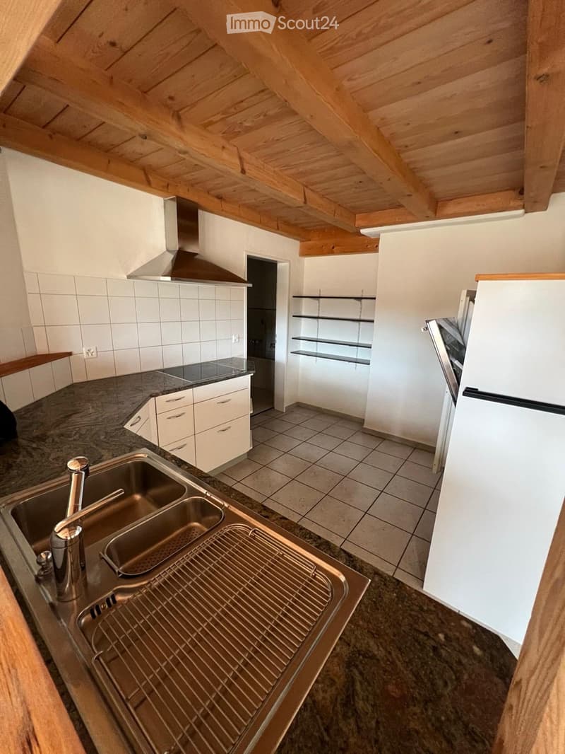 Modern kitchen with white cabinets, stainless steel sink, and granite countertop. Features include a built-in oven, refrigerator, and open shelving.