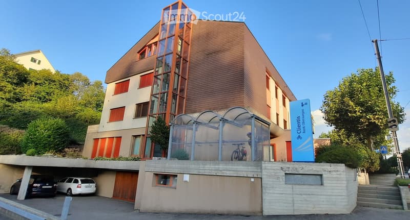 Building with car garage, modern design, red shutters, bicycles in front