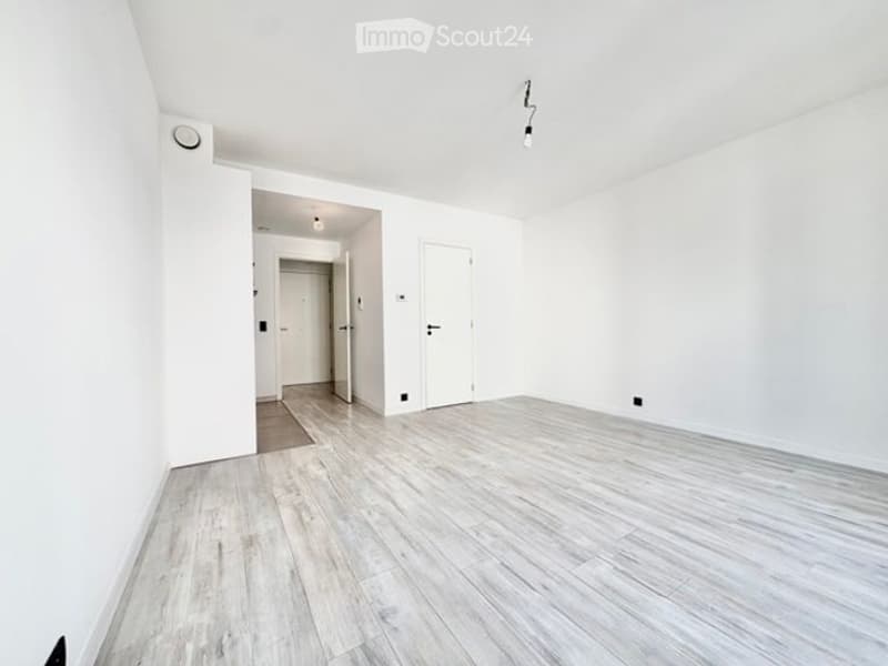Completely empty room with white walls and light wooden flooring. No furniture or equipment.