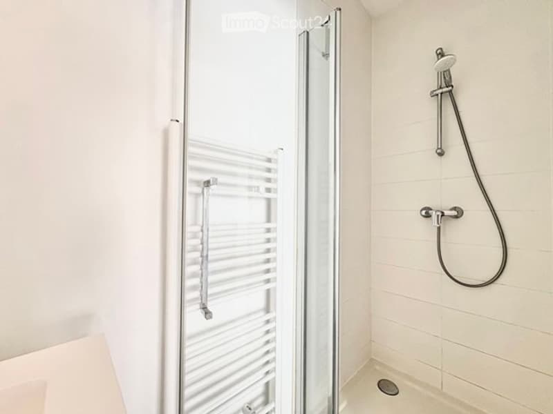 Modern bathroom with a glass-enclosed shower, a handheld shower hose, and a white radiator.
