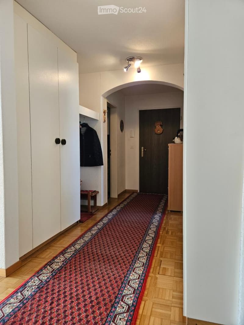 wooden floor, white walls, red carpet, wardrobe, wooden bench, door