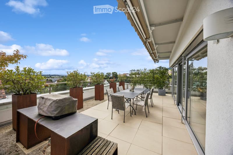 Balcony with tiled floor, covered seating area, dining table and chairs, potted plants, and a covered outdoor sofa.