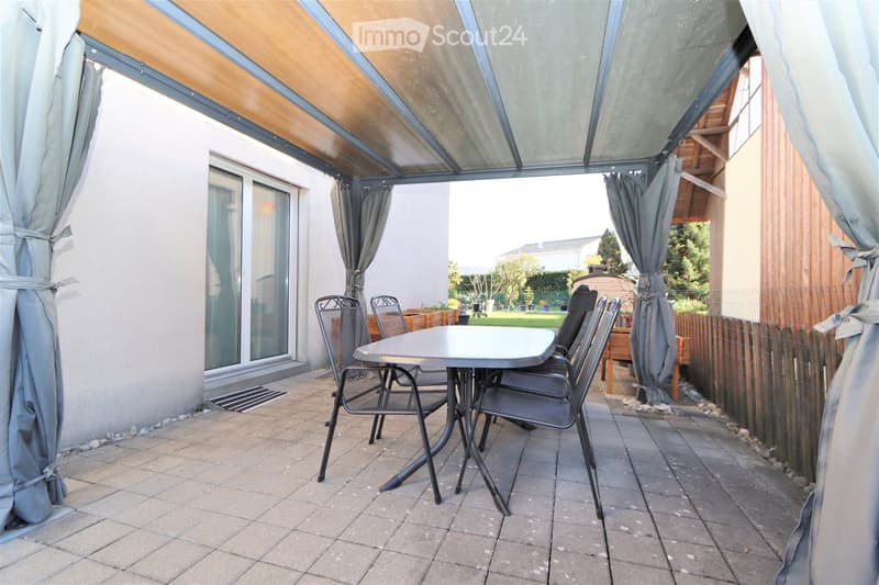 Balcony with a glass roof, tiled floor, and a small table with four chairs.