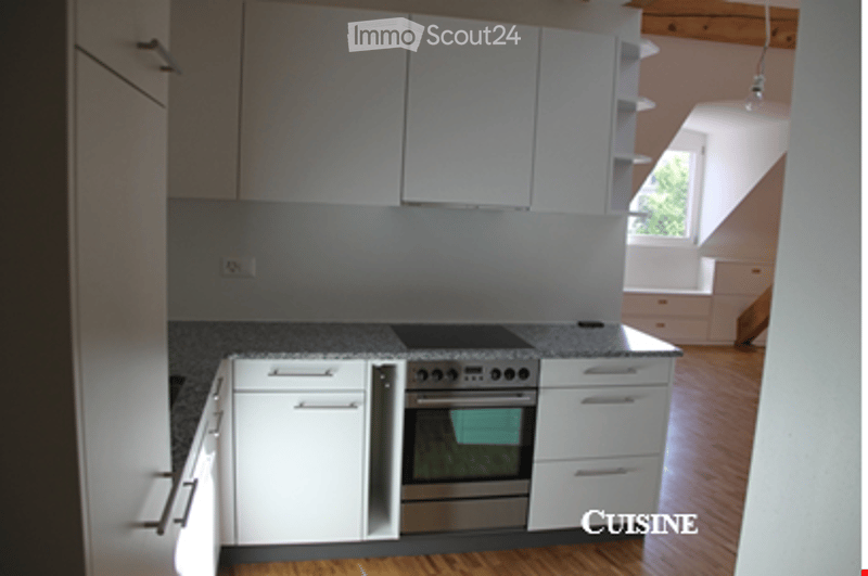 Modern kitchen with white cabinets, stainless steel oven, and granite countertop.