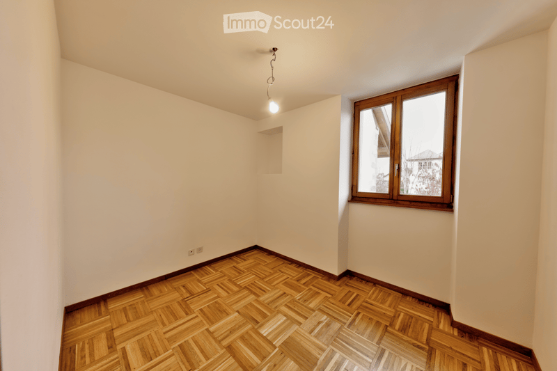 empty room, wooden parquet floor, white walls, window, power outlet