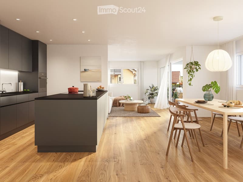 Modern kitchen and dining area with dark cabinets, a central island, and a dining table with chairs. Features pendant lighting, a hanging plant, and a painting on the wall.