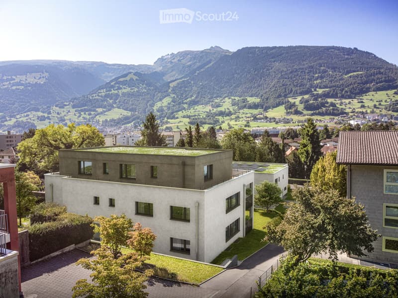 Aerial view of a multi-story residential building with a view of the mountains