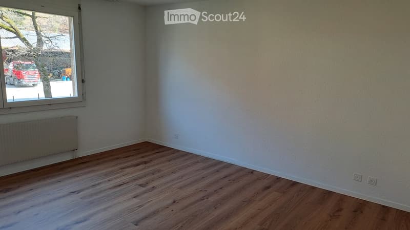 empty room, wooden floor, white walls, radiator, two power outlets