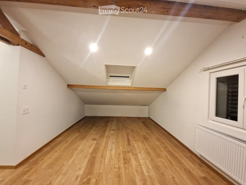 empty room, wooden floor, white walls, ceiling with beams, window, heater