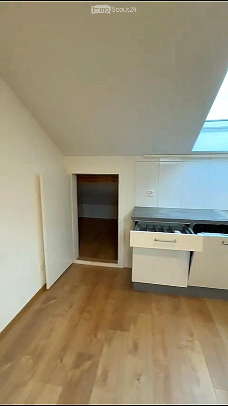 room with wooden floor and a cupboard under the stairs