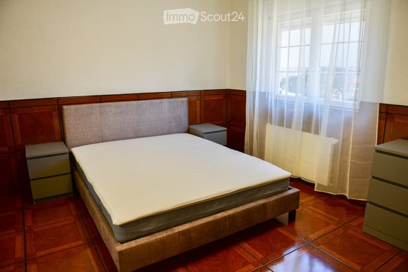 double bed, wooden panels, tiled floor, nightstands, window with white curtains
