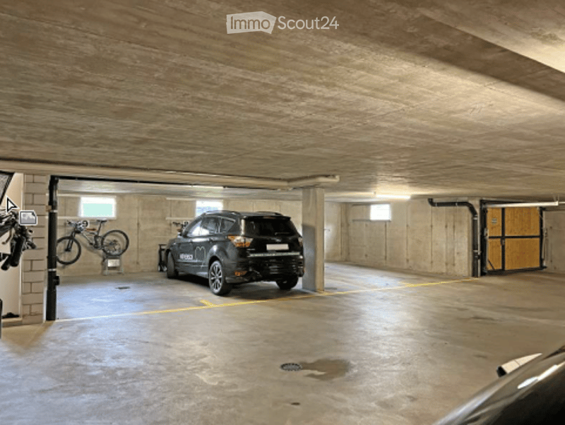 {"visible_features": ["Garage"], "type": "Garage", "objects": [], "description": "Underground garage with concrete floors and walls, wooden ceiling, parked SUV, bicycle on rack, and yellow parking lines.", "localized_descriptions": {"EN": "Underground gar