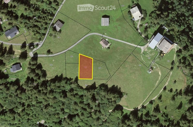 Aerial view of a rural property with multiple buildings, including houses and outbuildings, surrounded by green fields and trees. The highlighted area in yellow indicates a specific plot or lot.