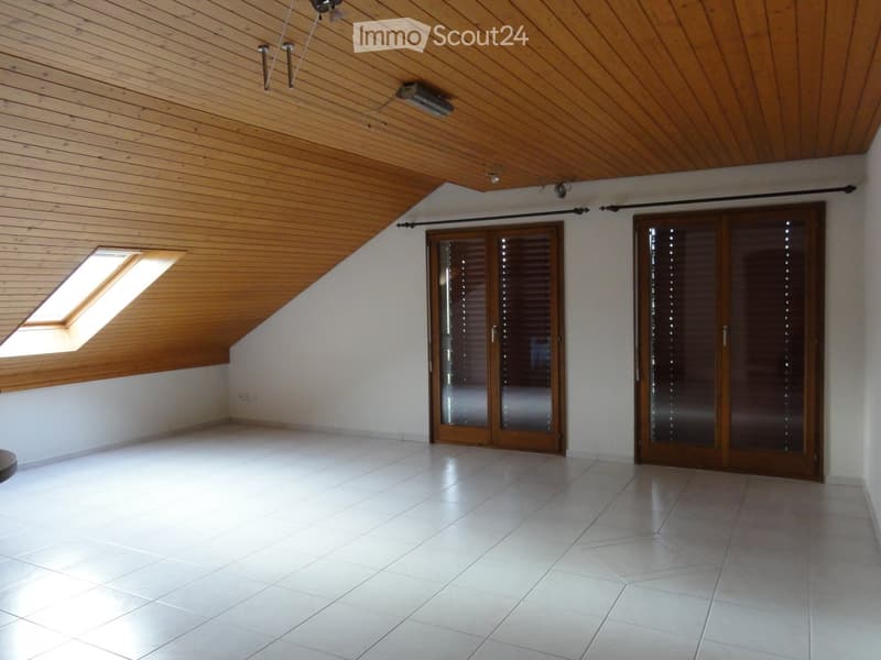 Empty room with white tiled floor, wooden ceiling, skylight window, and two wooden sliding doors.