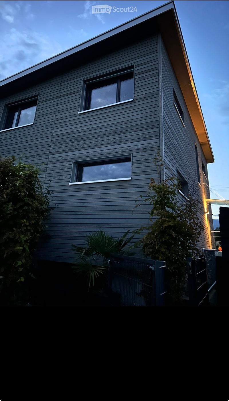 Exterior of a multi-story building with wooden siding, windows, and a sloped roof.