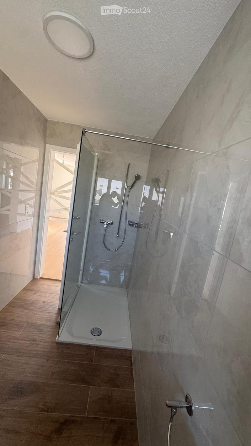 Modern bathroom with a glass-enclosed shower stall, multiple showerheads, and a sleek, contemporary design.