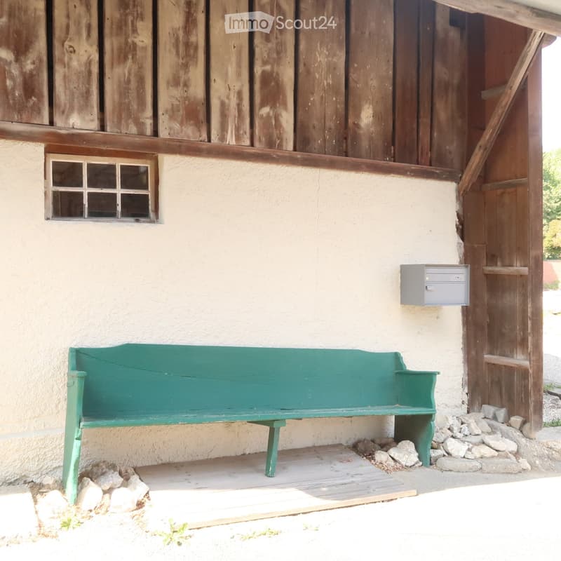 old wooden building, white painted wall, wooden door, window, green bench, mailbox
