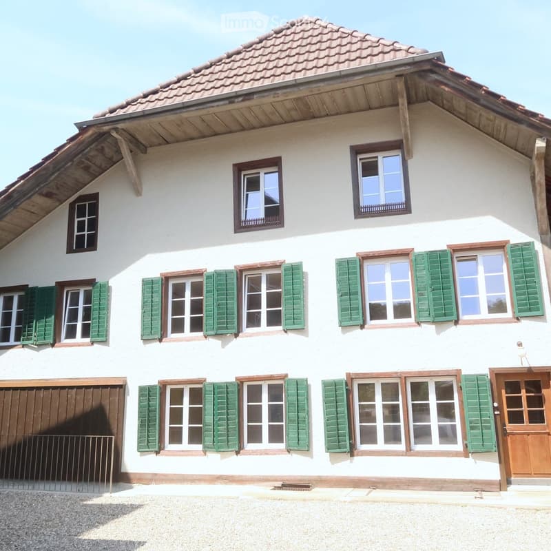 2-story building, white walls, red roof, brown trim, wooden garage door, brown front door, 13 windows with green shutters