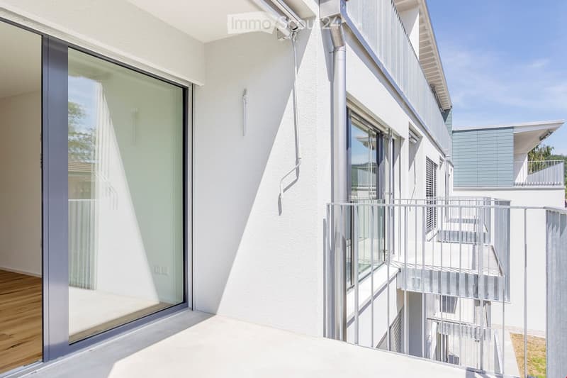 Glass sliding door, balcony with metal railings, white exterior wall