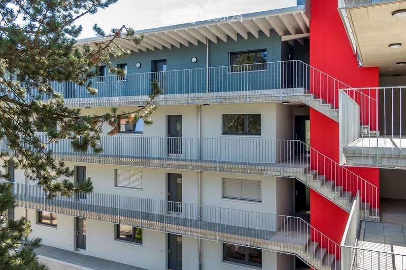 Modern multi-story apartment building with balconies and spiral staircase