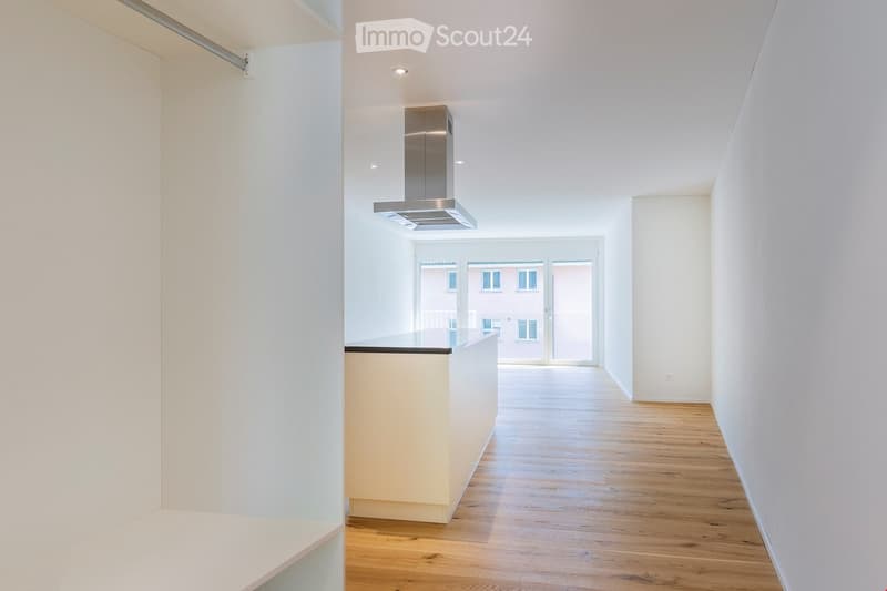 white walls, wooden floors, stainless steel chimney hood, white kitchen counter, glass balcony