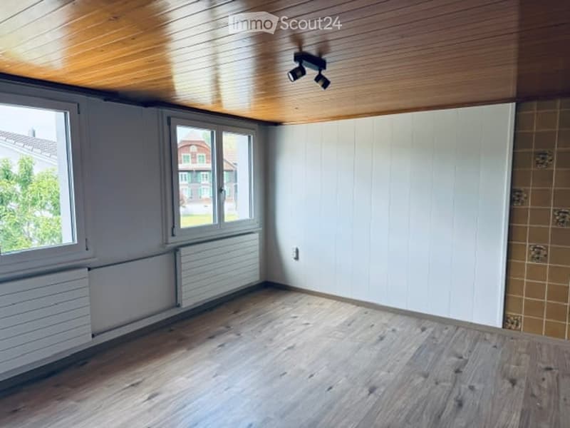 Empty room with wooden flooring, white walls, large windows, and a built-in closet. No furniture or equipment present.