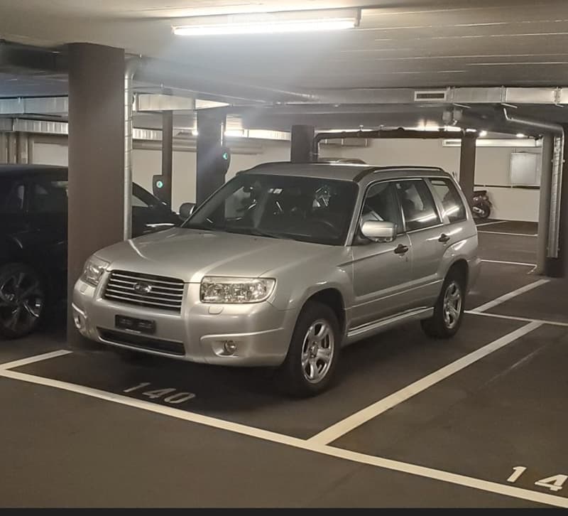 Underground parking area with a silver SUV parked in a designated spot, marked with the number 140.
