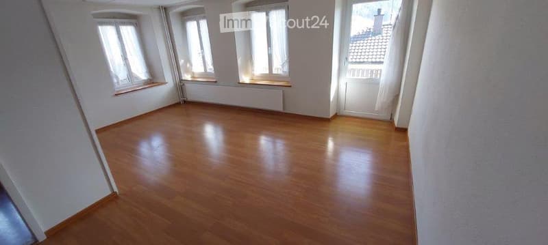 Empty room with wooden flooring, white walls, and multiple windows with white frames. No furniture or equipment present.