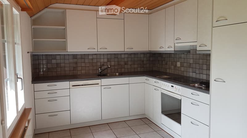 Modern kitchen with white cabinets, stainless steel appliances, and a tiled backsplash.