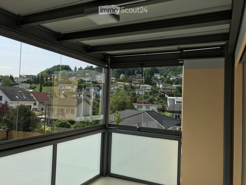 Large corner window with a view of a residential neighborhood, featuring multiple houses and greenery.