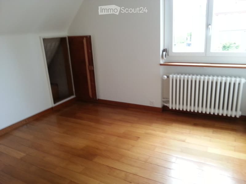 empty room, wooden floor, white walls, radiator, staircase opening, window