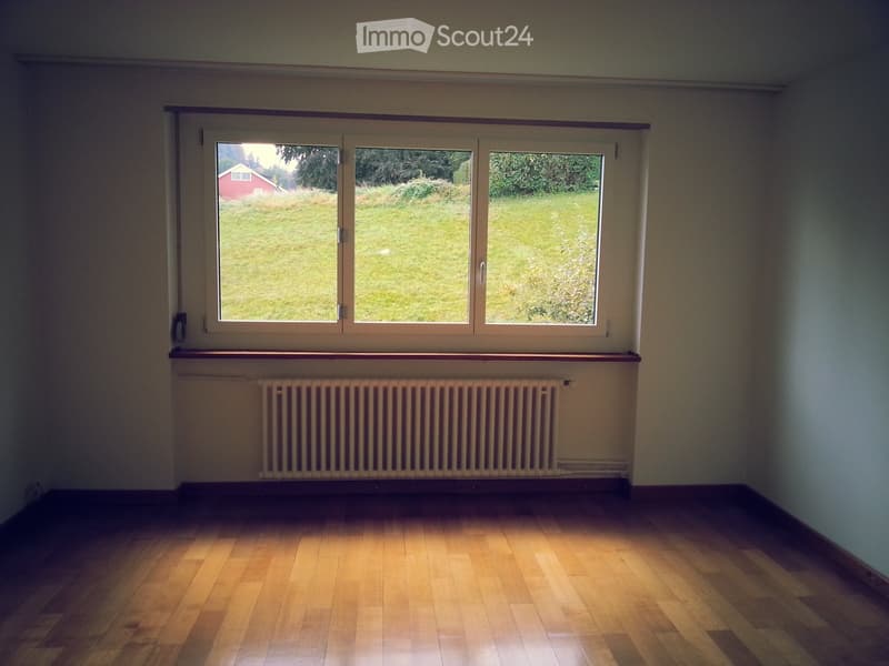 empty room, window, hardwood floor, radiator, view of grass field