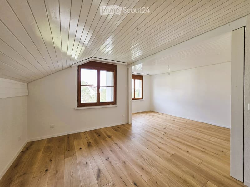 Empty room with wooden floors, white walls, and two windows. No furniture or equipment.