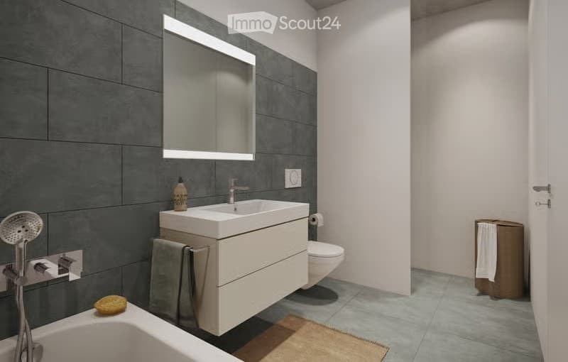 Modern bathroom with grey tiles, white sink, mirror, toilet, towel, and showerhead.