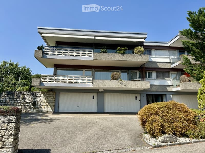 Modern two-story house with large garage, balconies, and contemporary design.
