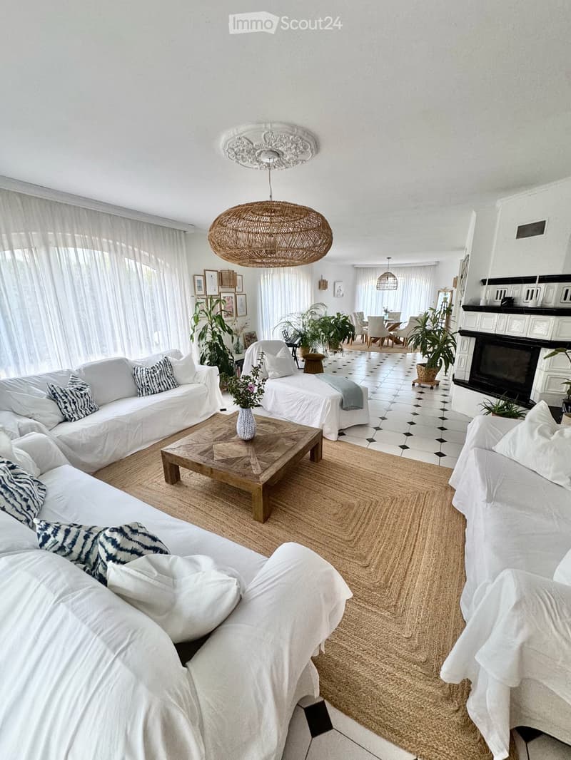 Wohnzimmer - vorne Kachelofen/TV-Raum, hinten Esstisch - hell durch bodentiefe Verglasungselemente, davon 8 Fenstertüren mit direktem Gartenzugang