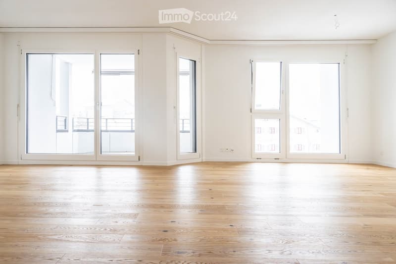 Empty room with hardwood floors, sliding glass doors, and a balcony outside.