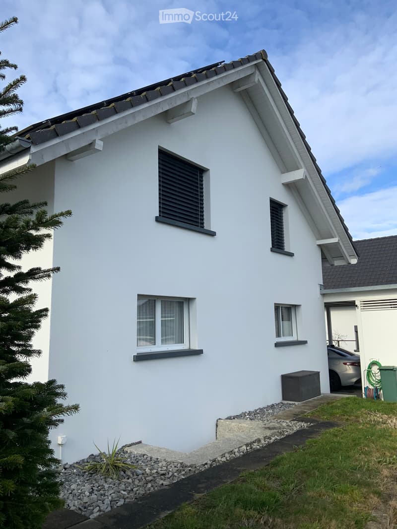 white facade, 4 windows, black shutters, green outdoor space, parked car