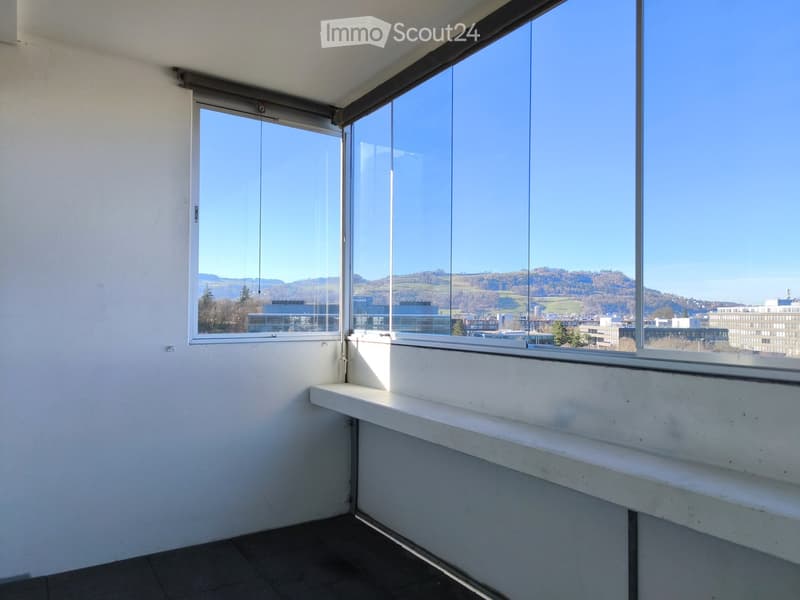 large windows, white walls, black floor, white bench, city view