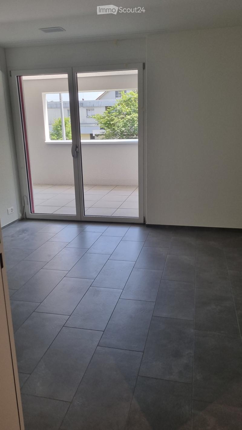 Empty room with tiled flooring and large sliding glass doors leading to a balcony area.
