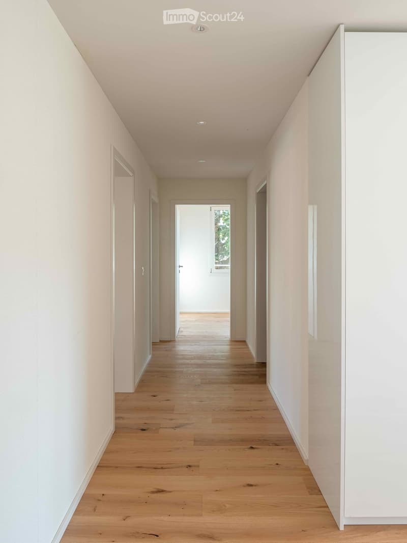 Empty hallway, hardwood floors, white walls, recessed lighting