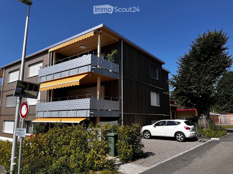 multi-story building, balconies, car parked in front