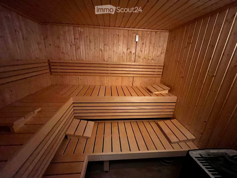 wooden sauna, wooden bench seats, steam heater on wall