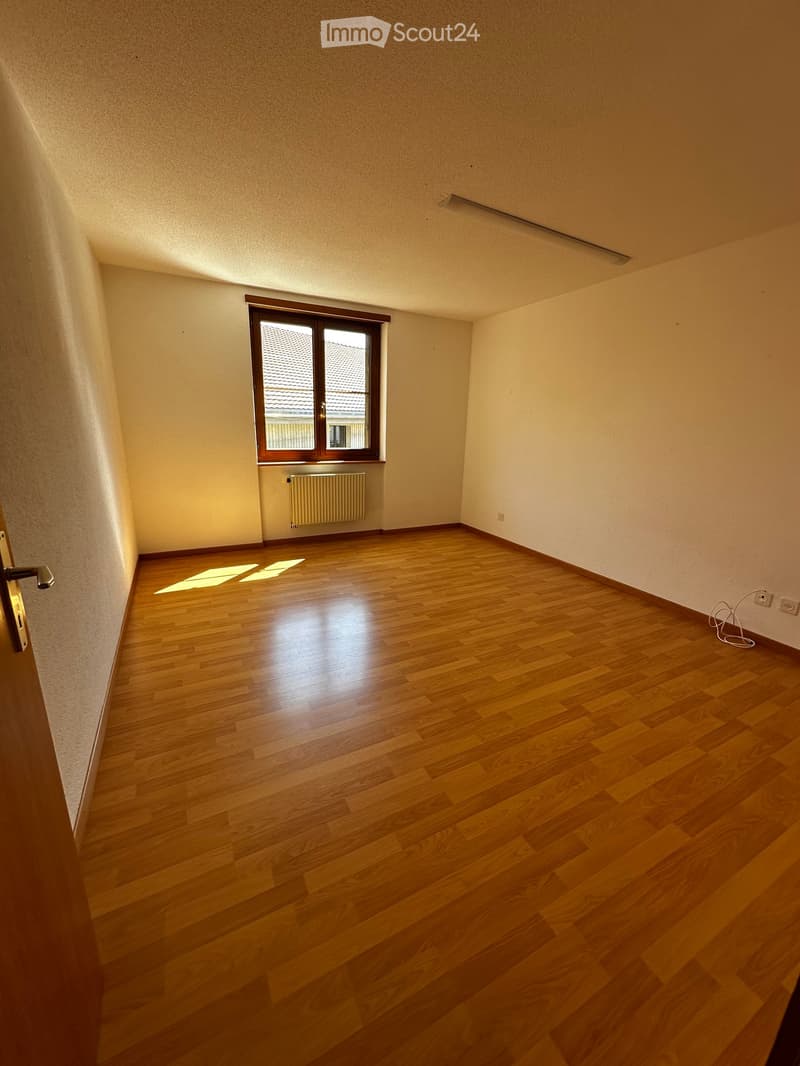 Empty room with wooden flooring, white walls, and a window with a radiator below it. No furniture or equipment is present.