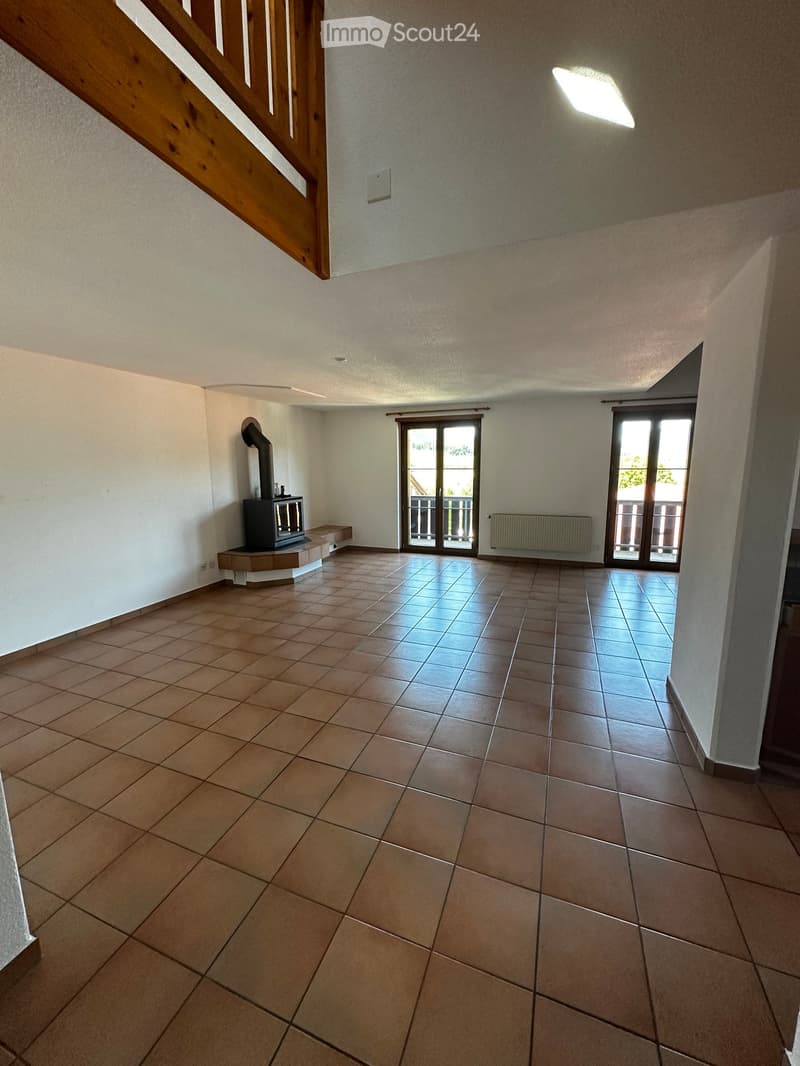 Empty room with tiled floor, white walls, and a fireplace on the left side. Two sets of glass doors lead to a balcony or outdoor area.